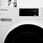 Zwei Haushaltsgeräte, eine Waschmaschine und ein Trockner, nebeneinander aufgestellt in einem modernen Badezimmer.