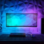 Ein kompaktes Solarladegerät mit ausgeklappten Solarpanels, das auf einem moosbewachsenen Felsen in der Natur liegt, daneben eine wiederbefüllbare Trinkflasche und ein Mehrwegkaffeebecher.