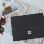 Zwei Bratpfannen mit dunklen, keramischen Antihaftbeschichtungen auf einem Holztisch, umgeben von nachhaltigen Küchenutensilien.